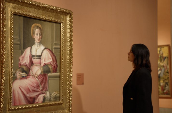 Photographer Rocío Aguirre admiring Pier Francesco Foschi’s Portrait of a Lady in an art gallery.