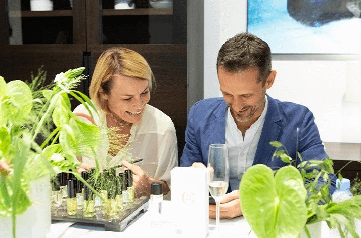 A man and a woman on a private private fragrance creation workshop with a glass of wine.
