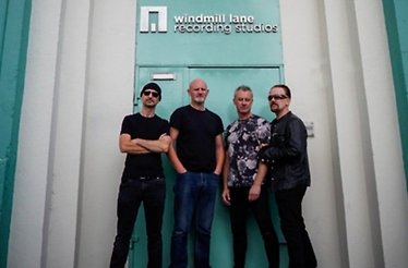 U2 band members pose outside Windmill Lane Recording Studios under the iconic sign.