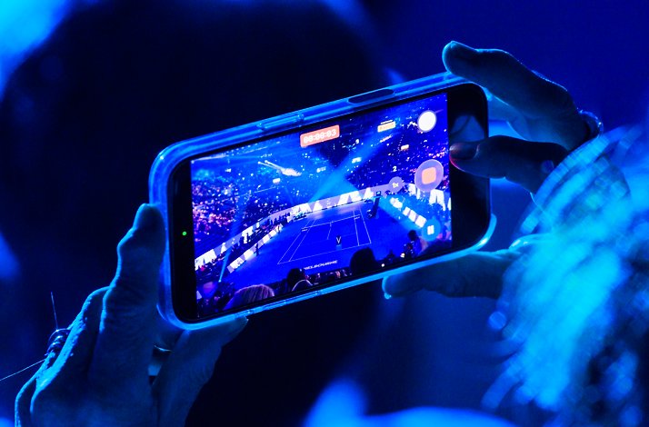 A fan capturing the live moment of the Australian Open with a phone.