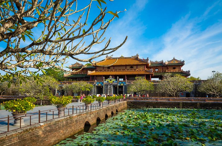 A wide shot of the Imperial Citadel of Hue Vietnam, showcasing a serene courtyard and the grand palace from the distance.