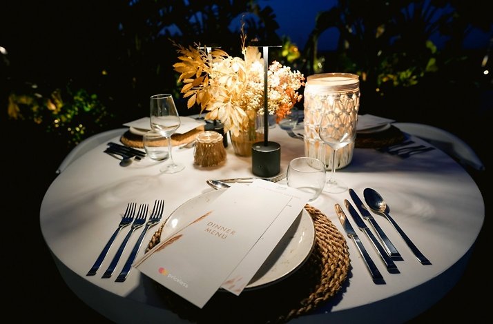 A beautiful, dimly-lit table ready to serve at home, arranged by a The Sage Experience butler. 