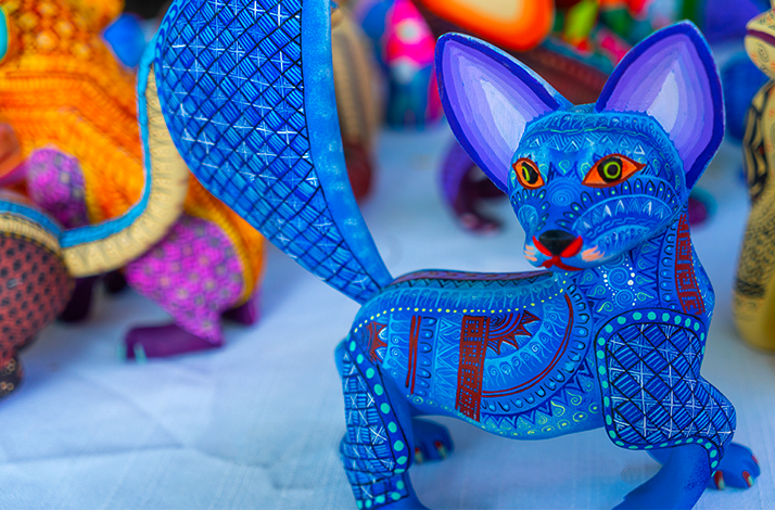 A bright blue, hand-painted figurine of a fox-like creature is on display.