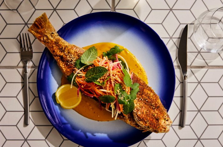 Whole spiced fish with fresh herb salad served at Superblue Miami's Blue Rider restaurant.