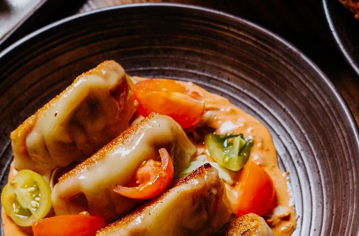 Pan-fried dumplings with cherry tomatoes and creamy sauce at Pace NYC.