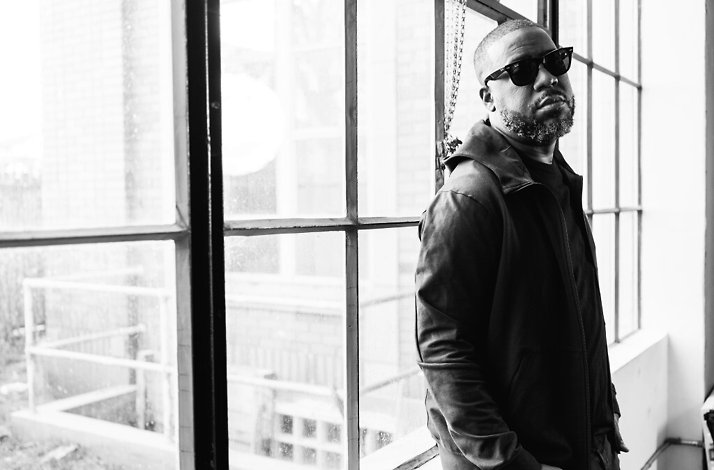 Black and white photo of artist Robert Glasper leaning at the window.